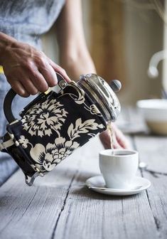 a person pouring tea into a cup