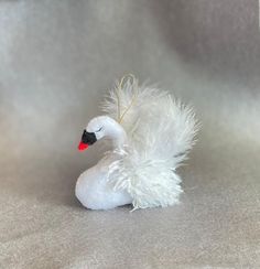 a white swan ornament sitting on top of a gray cloth covered tablecloth