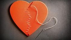 an orange heart cut in half with thread