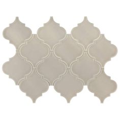 a white tile with an intricate design on the top and bottom half, in various sizes