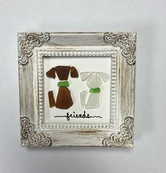 two dogs made out of glass sitting in a frame with the word friends written on it