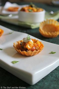 small appetizers are displayed on white plates