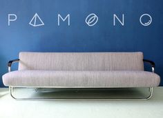 a couch sitting in front of a blue wall with the word ramon written on it