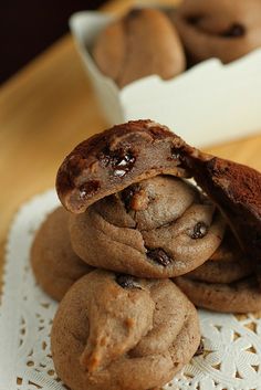 a stack of cookies sitting on top of a white doily next to a box of cookies