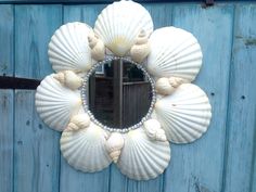 there is a mirror made out of seashells on the side of a building