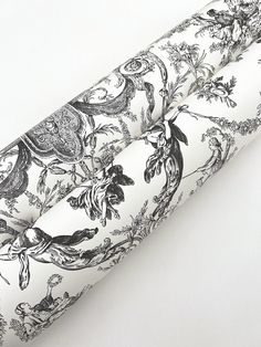 an umbrella with black and white floral designs on it's cover is laying upside down