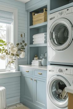 a washer and dryer in a small room with blue paint on the walls