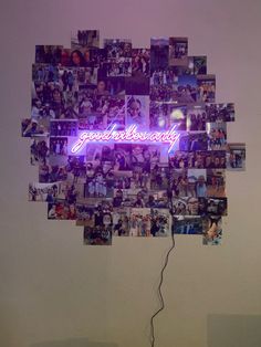 a purple neon sign that says good luck university surrounded by photos and wires in front of a white wall