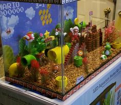 a display case filled with plants and mario bros figurines on top of rocks