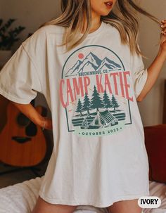 a woman standing on top of a bed wearing a white t - shirt that says camp kate