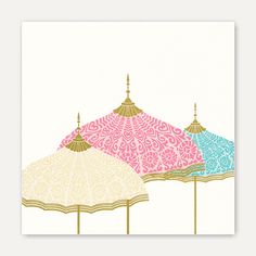 three colorful umbrellas sitting next to each other on top of a white surface with gold trim