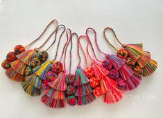 multicolored tasselled necklaces on white background