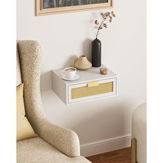 a white table with a vase and flowers on it in front of a framed painting