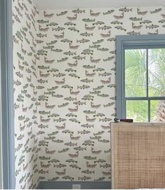 a room with a window and wallpaper that has fish on it