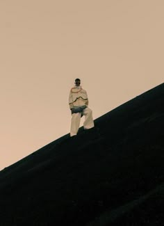 a man standing on top of a black hill