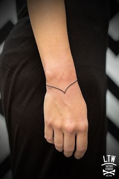 a woman's arm with a small heart tattoo on it