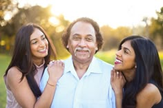 an older man and two young women smiling