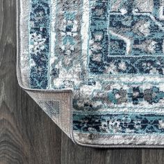 a blue and white rug on top of a wooden floor