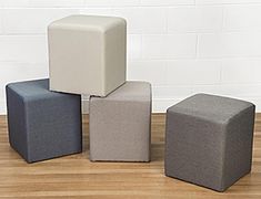 four different colored cubes sitting on top of a wooden floor