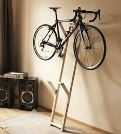 a bike is hanging on the wall next to speakers and a speaker system in front of a window