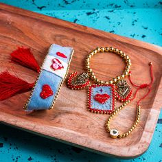 two bracelets on a wooden tray with beads and tassels attached to them