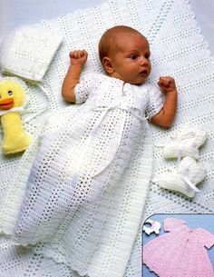 a baby laying on top of a white blanket next to a yellow duck