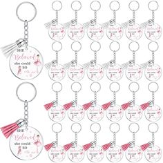 a set of 12 key chains with pink tassels on each one and the words she