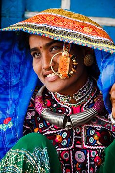 a woman wearing a colorful hat and nose ring