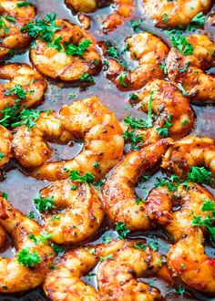 cooked shrimp with sauce and parsley in a pan