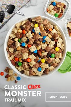 a bowl full of chex mix next to two containers with candy in them on a table