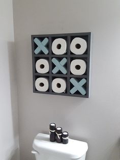 a white toilet sitting in a bathroom next to a black and white wall mounted object