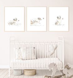 a baby's room with two prints on the wall