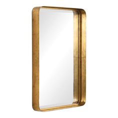 a gold framed mirror sitting on top of a white wall