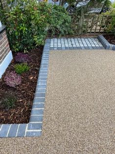 a concrete walkway in the middle of a garden