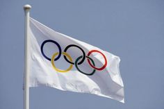 the olympic flag is flying high in the sky