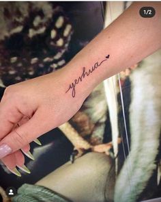 a woman's hand with a small tattoo on it that reads, yehou