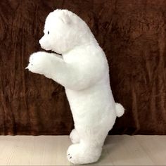 a large white teddy bear standing on its hind legs