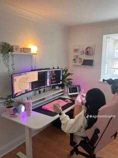 a person sitting at a computer desk with two monitors