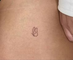 a small tattoo on the back of a woman's stomach