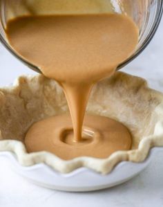 someone pouring caramel sauce into a pie crust