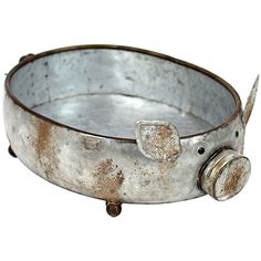 an old metal bowl with a pig on the side and two wheels attached to it