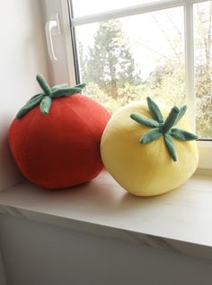 two stuffed tomatoes sitting on top of a window sill next to a large tomato