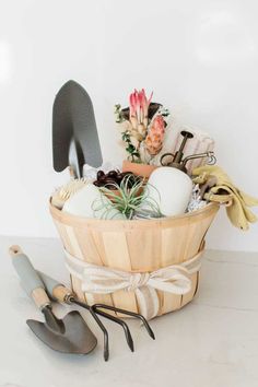 a wooden basket filled with gardening utensils