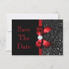 save the date card with red ribbon and diamond brooch on black glittered background