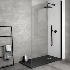 a walk in shower sitting next to a towel rack