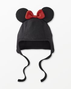 a mickey mouse hat with a red bow on the front and black ears, sitting on top of a white surface