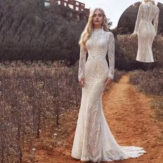 a woman in a white dress standing on a dirt road