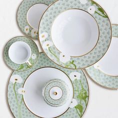 four plates and two cups with flowers on them