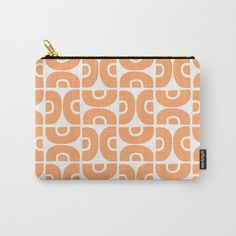 an orange and white geometric pattern carry - all pouch with gold zipper closure on the front