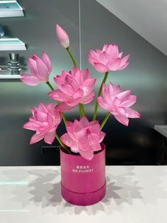 a pink vase with flowers in it on a table